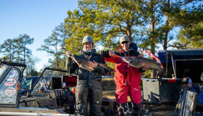 man and woman in boat with large catfish